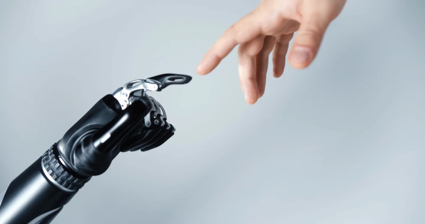 A human hand reaches toward a robotic hand.